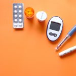 Insulin Preparations and Glucose Meter on Orange Background.